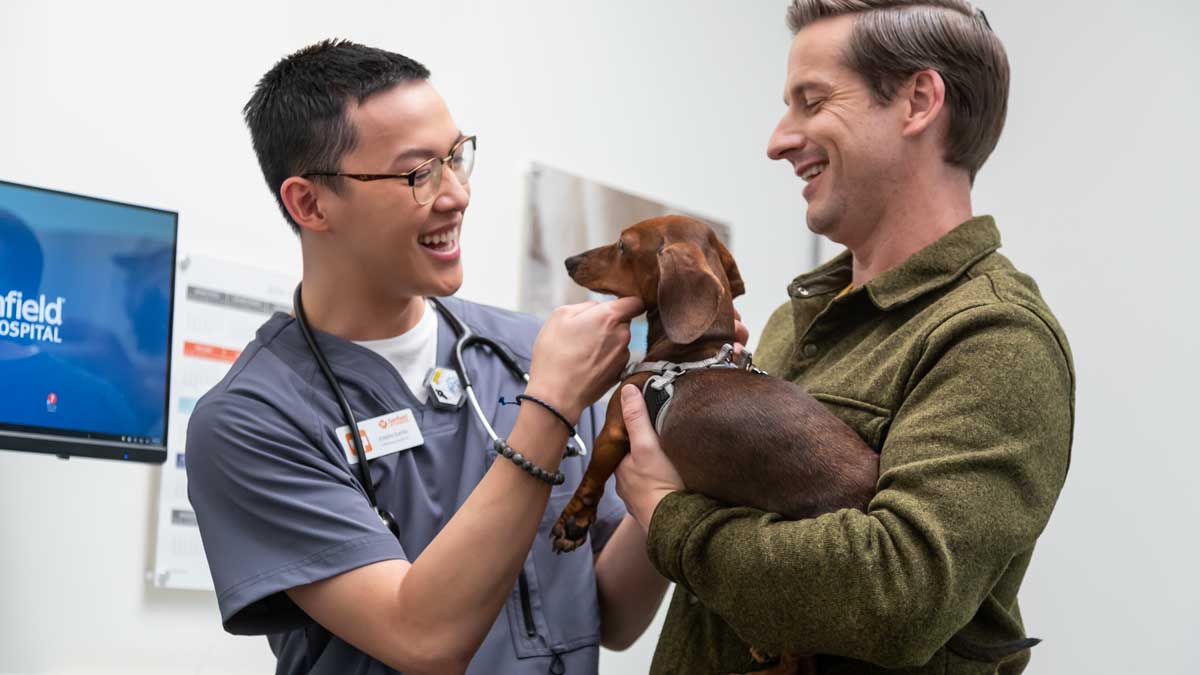 Veterinary assistant Joseph Slater welcomes a client and his Dachshund