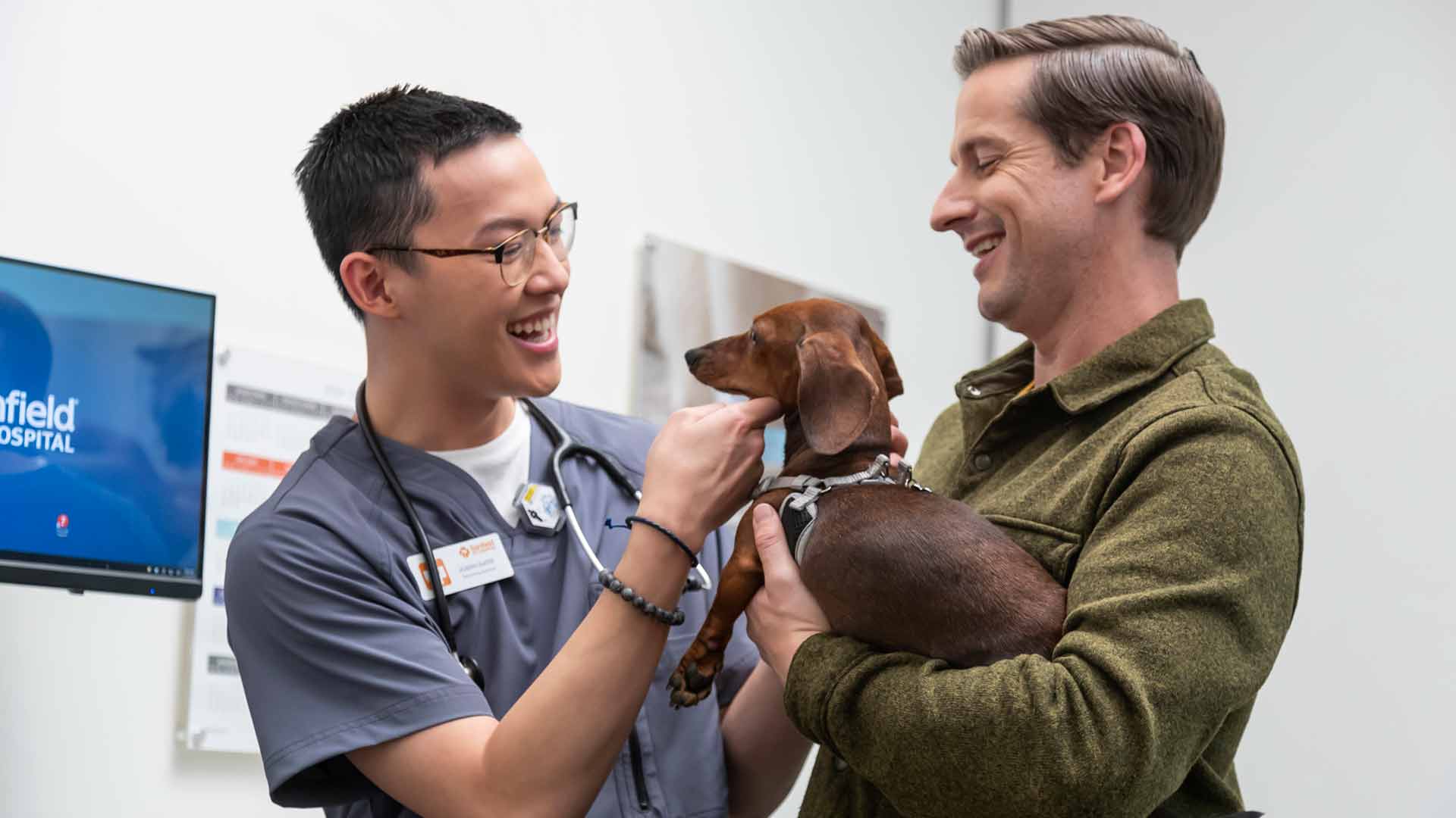 Veterinary assistant Joseph Slater welcomes a client and his Dachshund