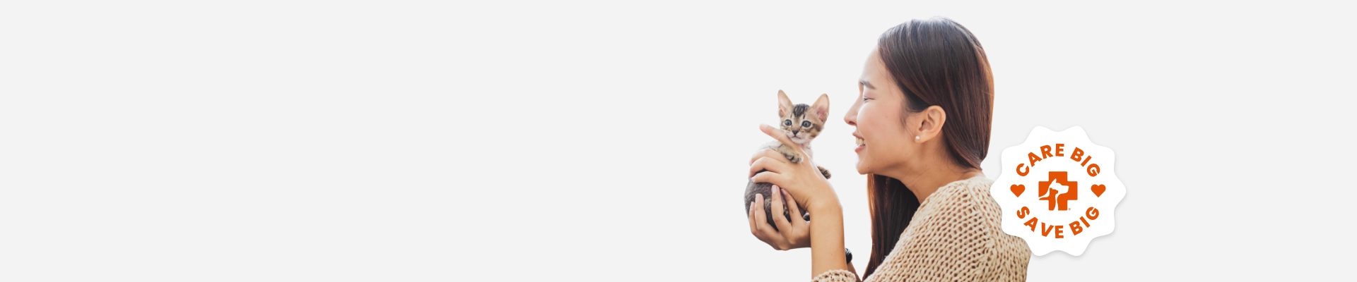 A woman with a small kitten in her hands