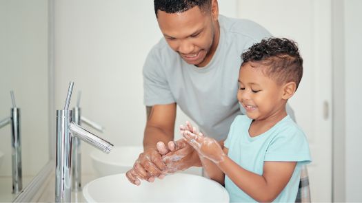 A child and his father washing their hands